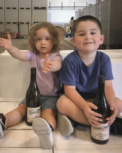 Cooper and River seated with bottles bearing their names