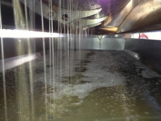 Fresh Chardonnay juice running from a press into a collection pan